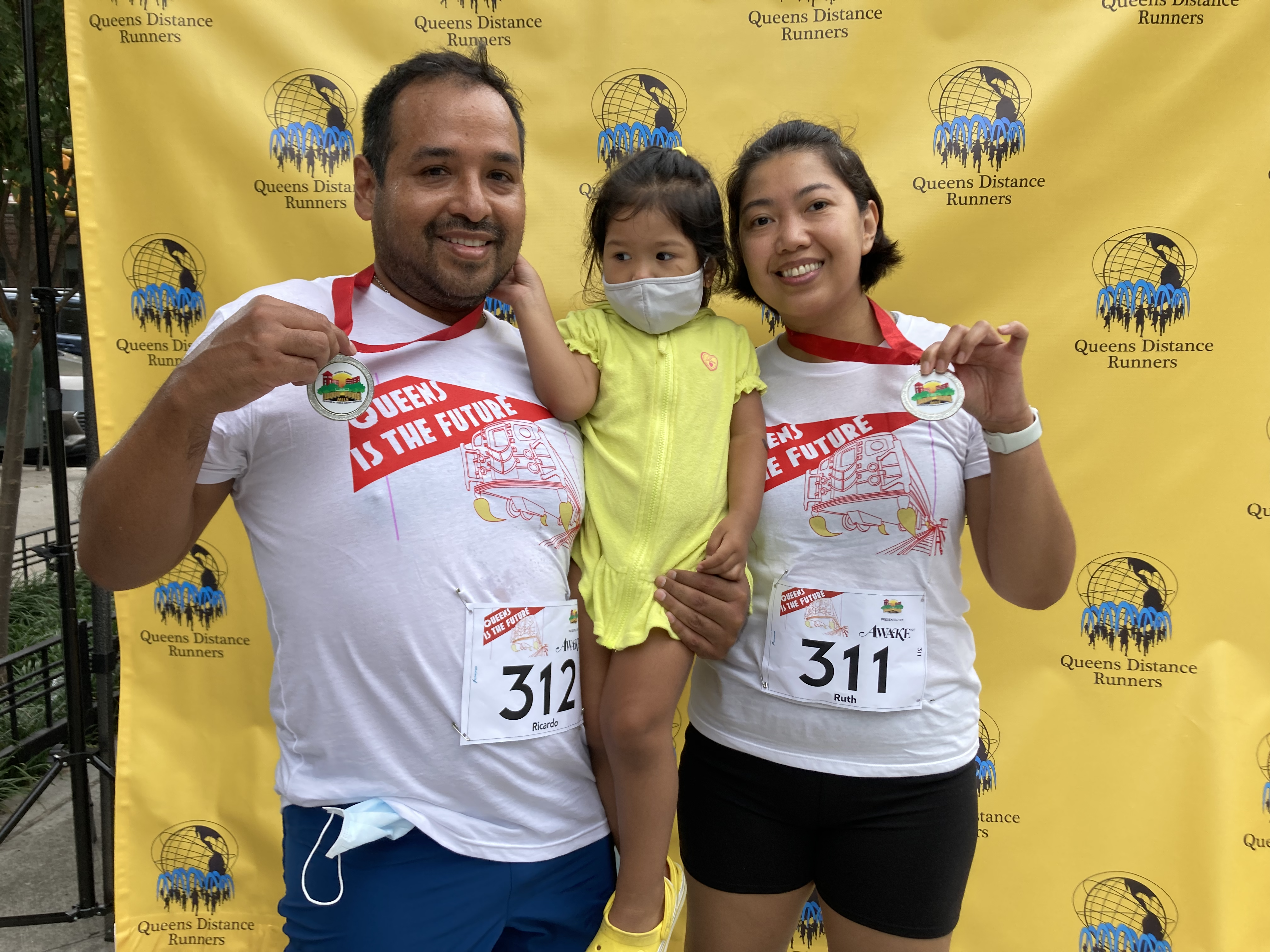 A young family wearing Queens Is The Future t-shirts at the Jackson Heights Mile