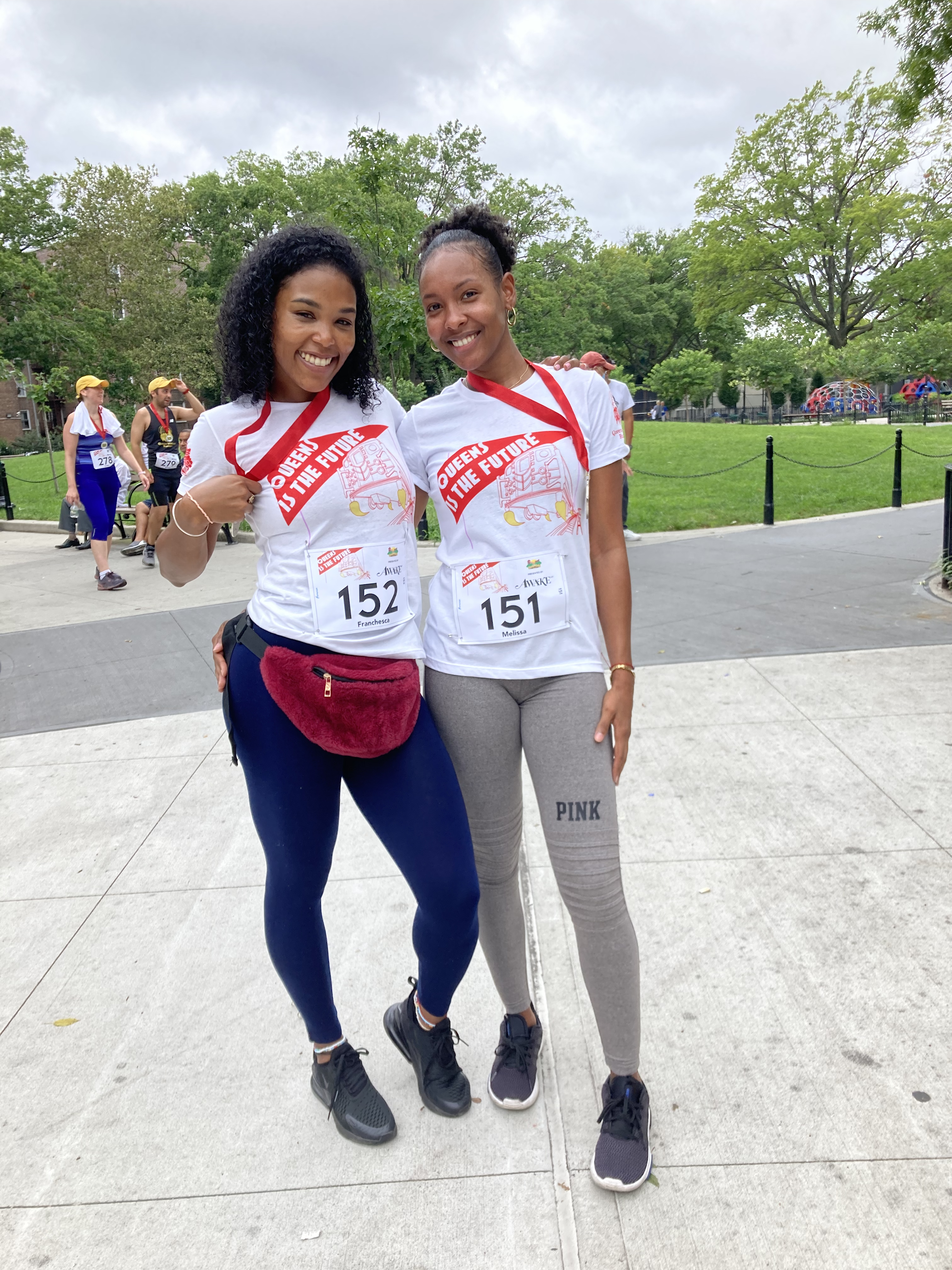 Two young women wearing QITF t-shirts at the Jackson Heights Mile