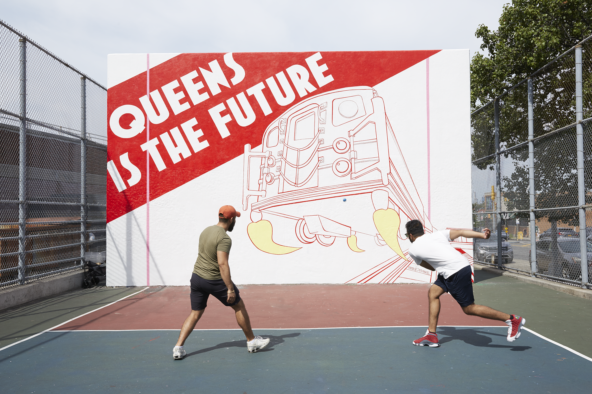 The QUEENS IS THE FUTURE mural after restoration. Two men playing handball.